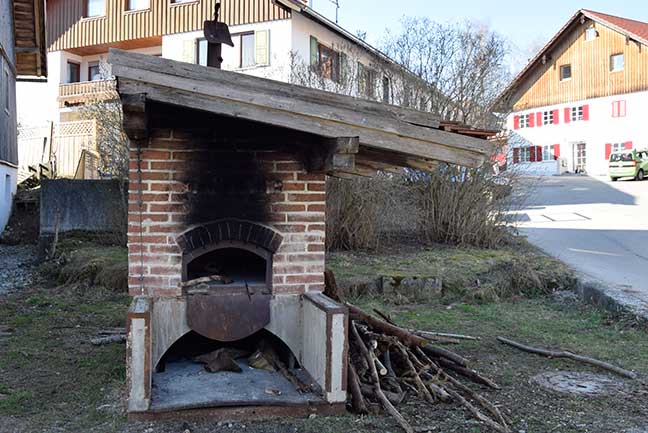 Kloster Irsee - öffentlicher Holzbackofen mit Brennmaterial, Brotschieber, Axt und Aschezieher