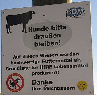Schild: Auf diesen Wiesen werden hochwertige Futtermittel produziert, Hunde bitte draußen bleiben! 